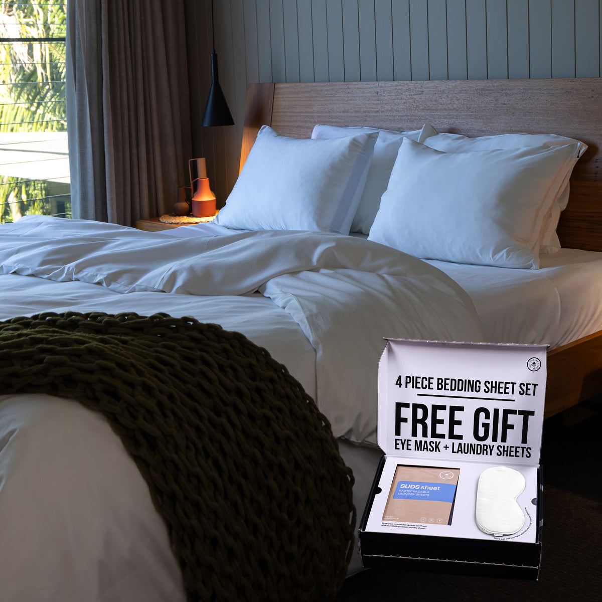 Bedding set packaging with eye mask and laundry sheets on a bed