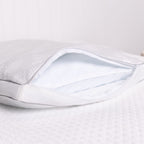 Close-up of a white pillow with a clear plastic cover on a light gray background