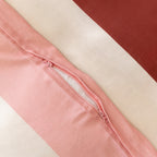 Close-up of a striped quilt cover featuring a concealed zipper closure, highlighting the secure fastening detail and soft woven fabric in pink, cream, and burgundy tones.