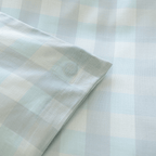 Close-up of a light blue gingham quilt cover corner tie, highlighting the internal attachment detail designed to help keep the quilt insert securely in place