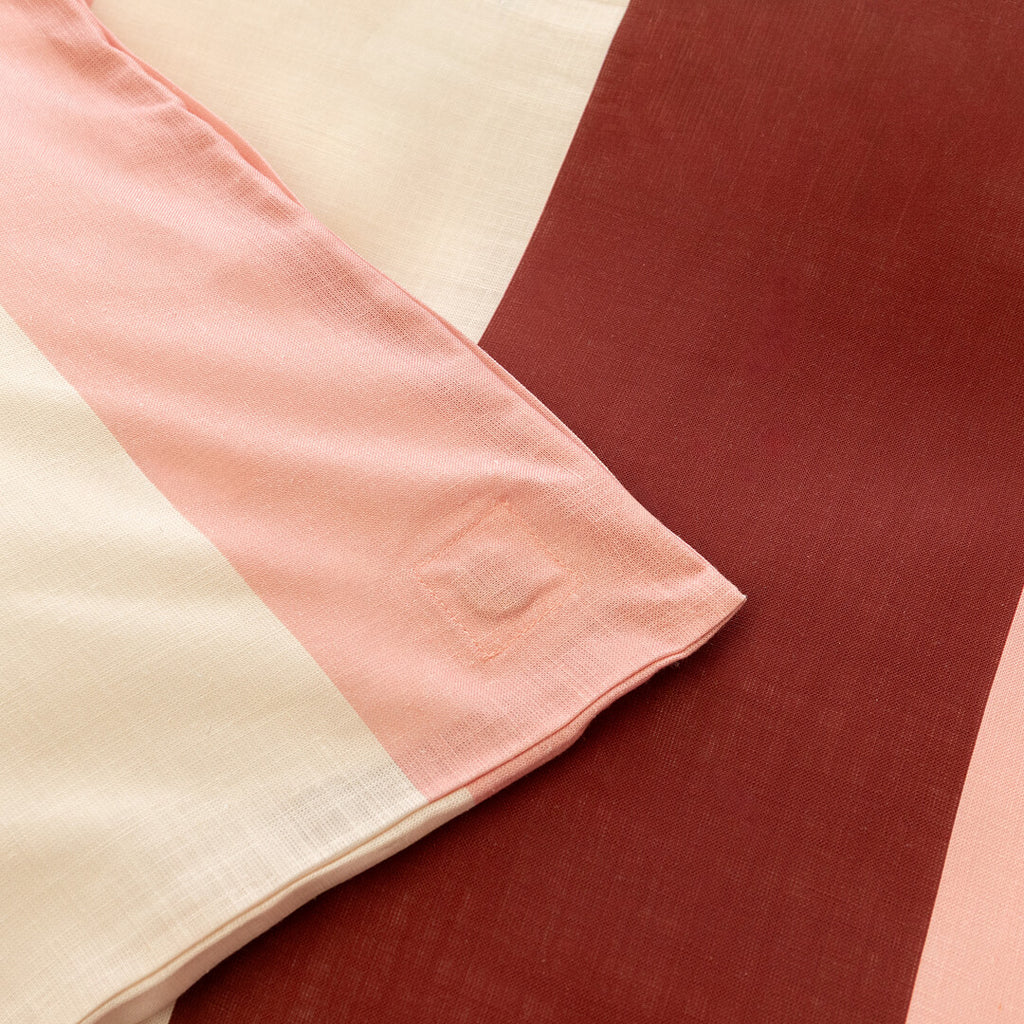 Close-up of a quilt cover corner tie detail in blush pink fabric, designed to help keep the quilt insert securely in place inside the cover.