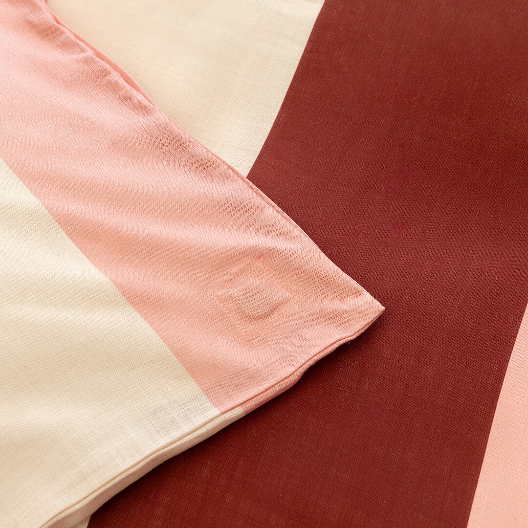 Close-up of a quilt cover corner tie detail in blush pink fabric, designed to help keep the quilt insert securely in place inside the cover.