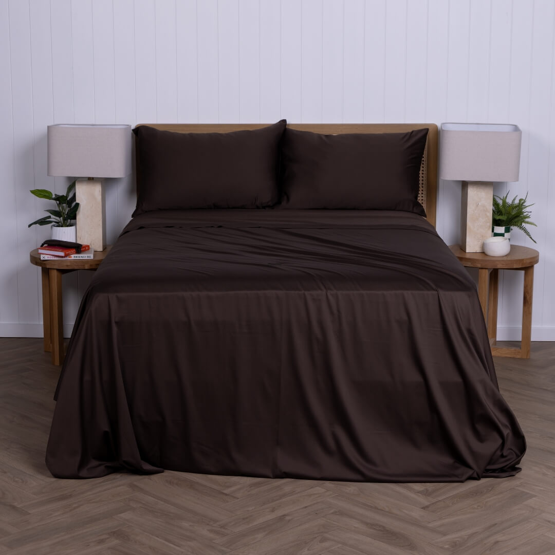 Brown sheet set on a bed with matching pillows in a bedroom setting.