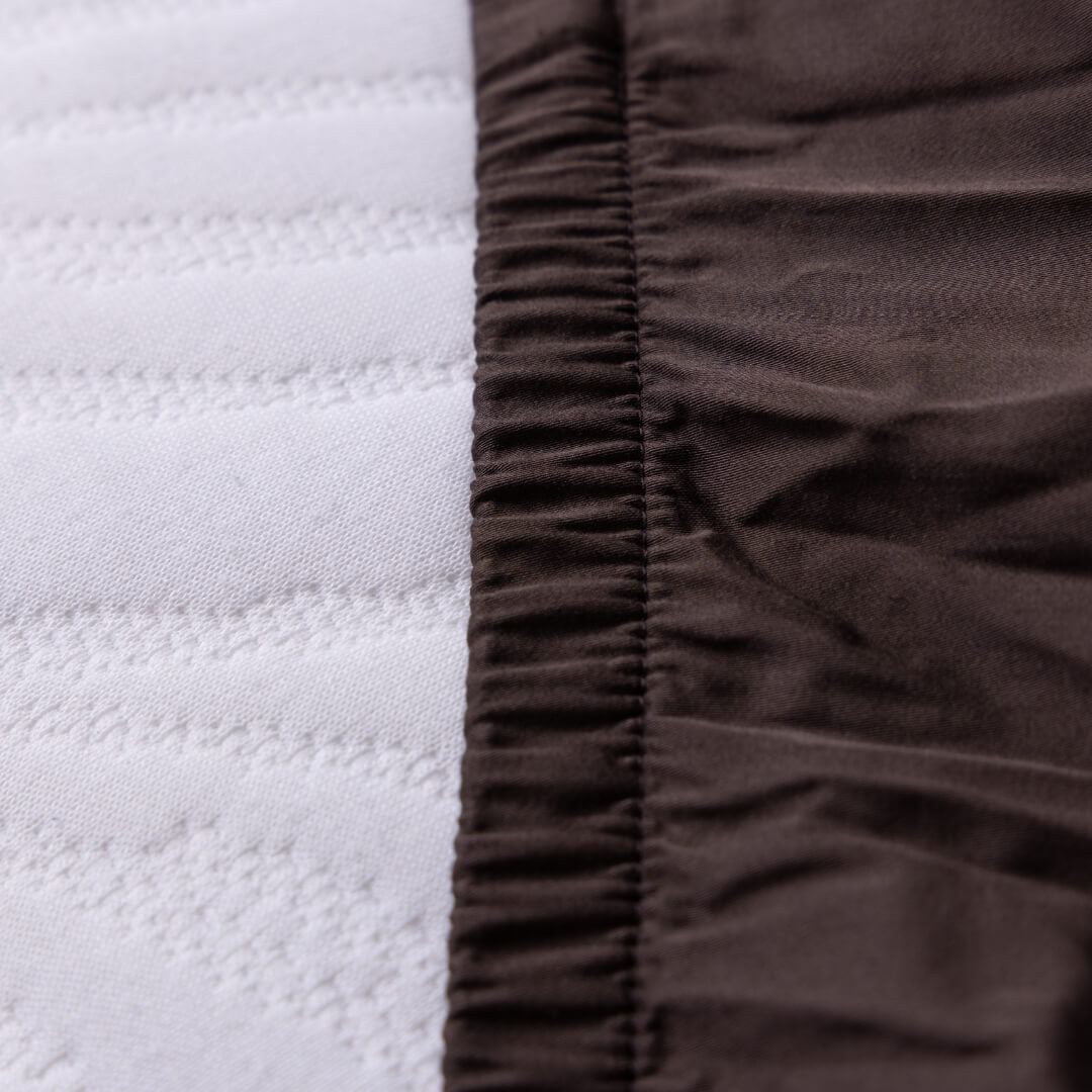 Close-up of brown textured fabric and elastic end on the Hunter Valley fitted sheet.
