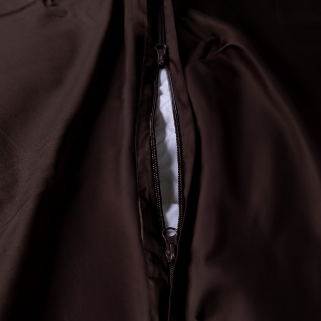 Close-up of a brown quilt cover with a zipper on the end.