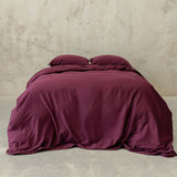 Burgundy colour Quilt Cover on bed with Stone Background 