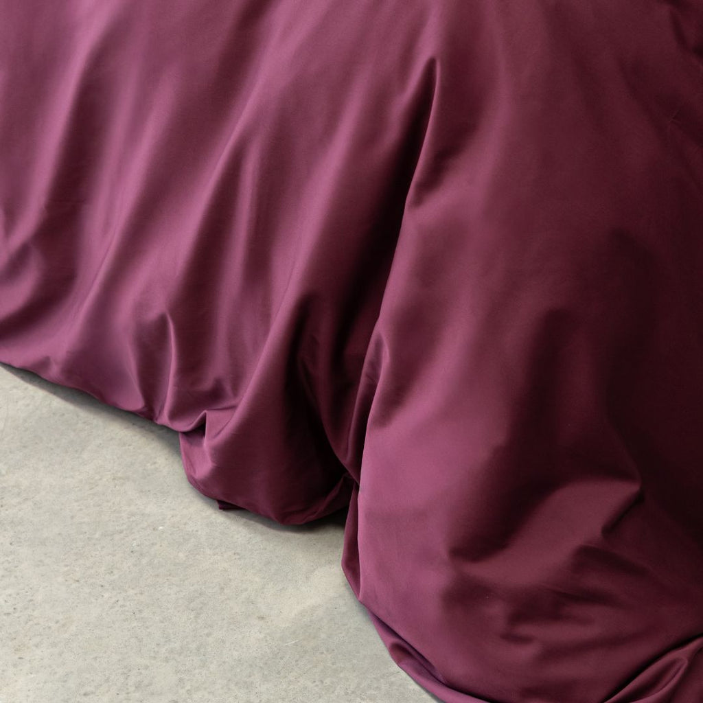 Close-up of burgundy satin fabric on a neutral background