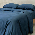Blue bedding set on a bed with a neutral background