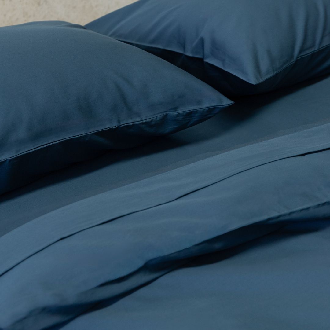 Blue bedding set with two pillows on a bed