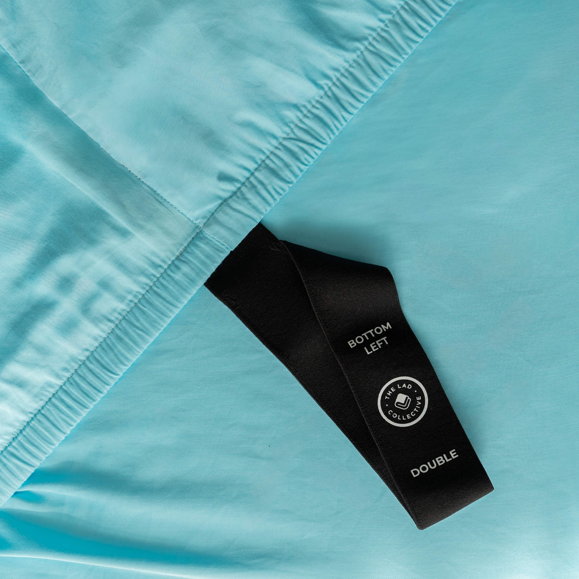 Close-up of a blue fabric with a black label on a light blue background