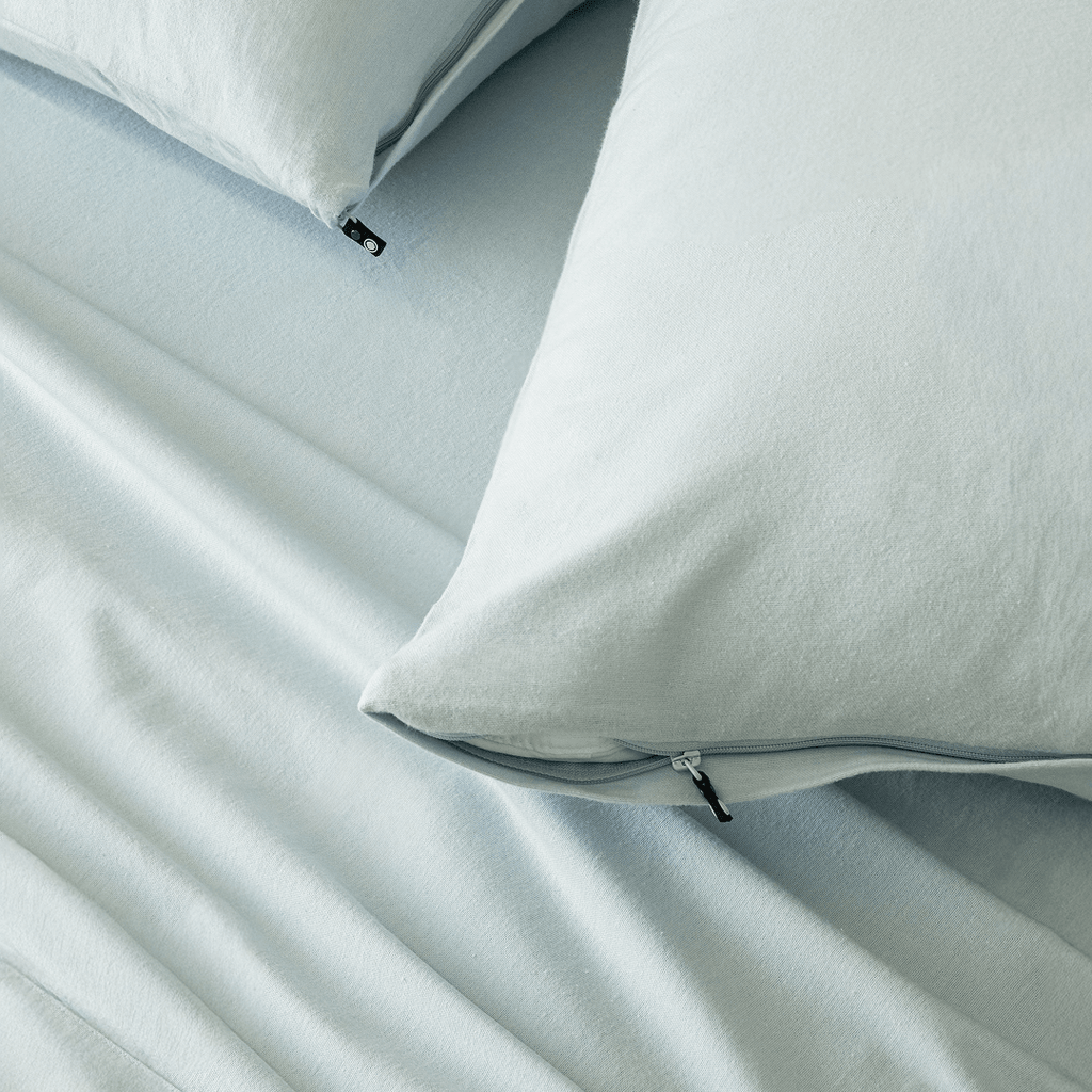 Close-up of light blue pillowcases with concealed zipper closures, showcasing the secure fastening detail and soft brushed fabric texture.
