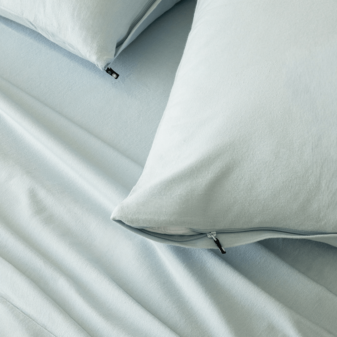 Close-up of light blue pillowcases with concealed zipper closures, showcasing the secure fastening detail and soft brushed fabric texture.