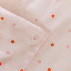 Close-up of quilt cover magnetic corner with pink polka dots on a matching fabric background.