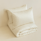 Neatly folded cream floral print quilt cover with two matching pillowcases stacked behind it