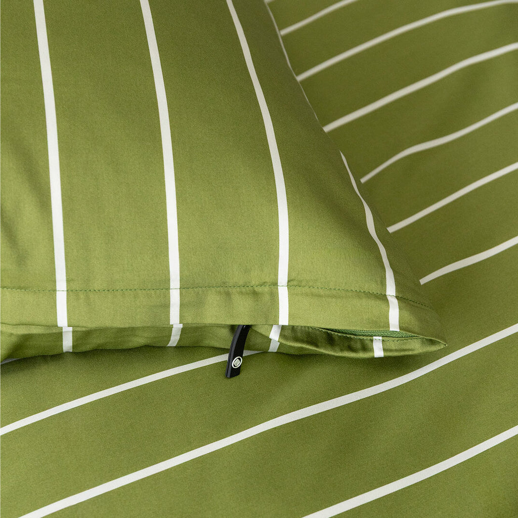 Close-up of green pillowcase with white stripes and a zipper.