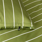 Close-up of green pillowcase with white stripes and a zipper.