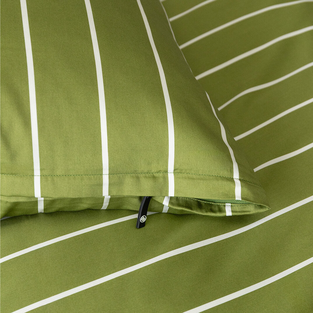 Close-up of green pillowcase with white stripes and a zipper.
