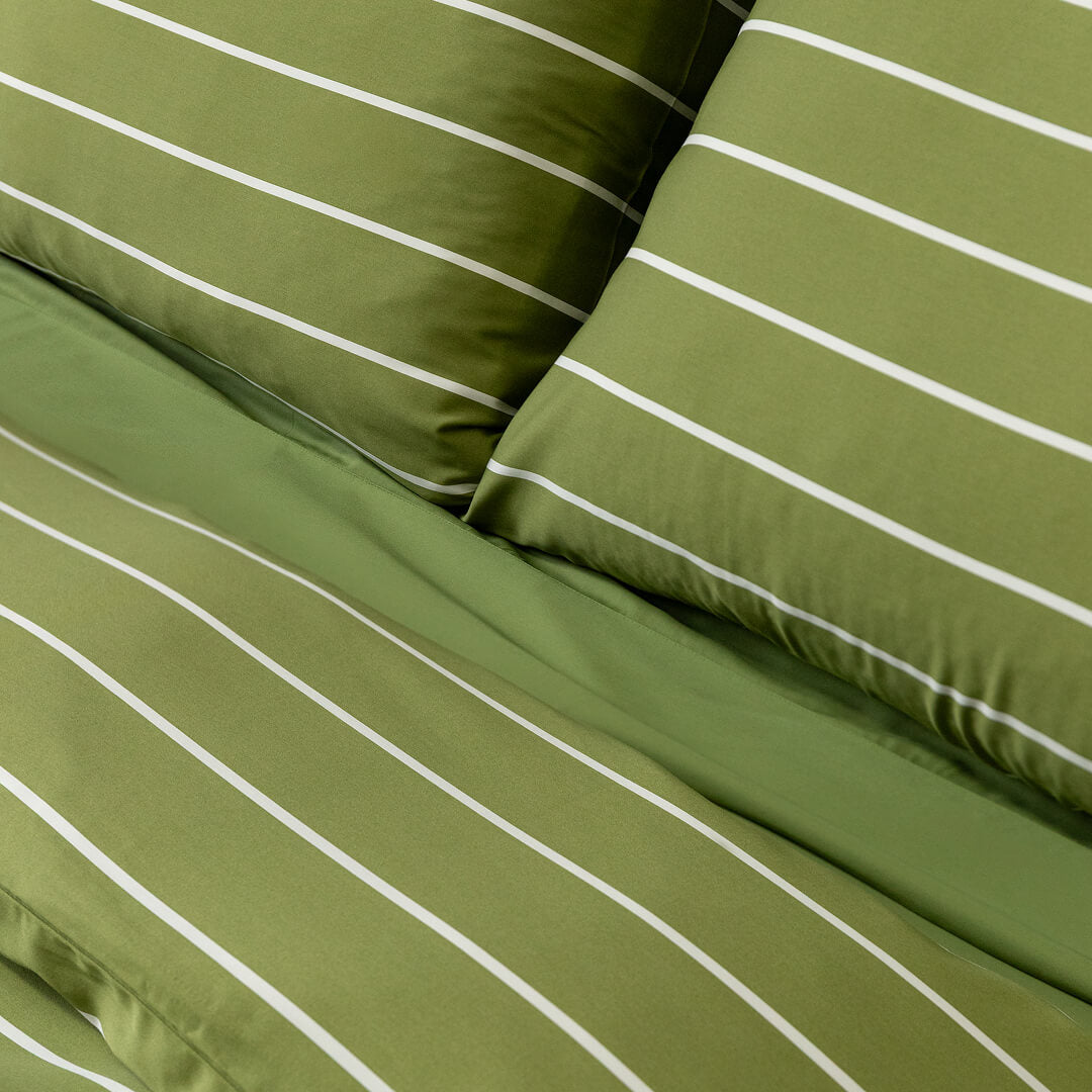 Green striped bedding set with white stripes on a plain background.