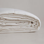 Off-white coloured cooling blanket folded.