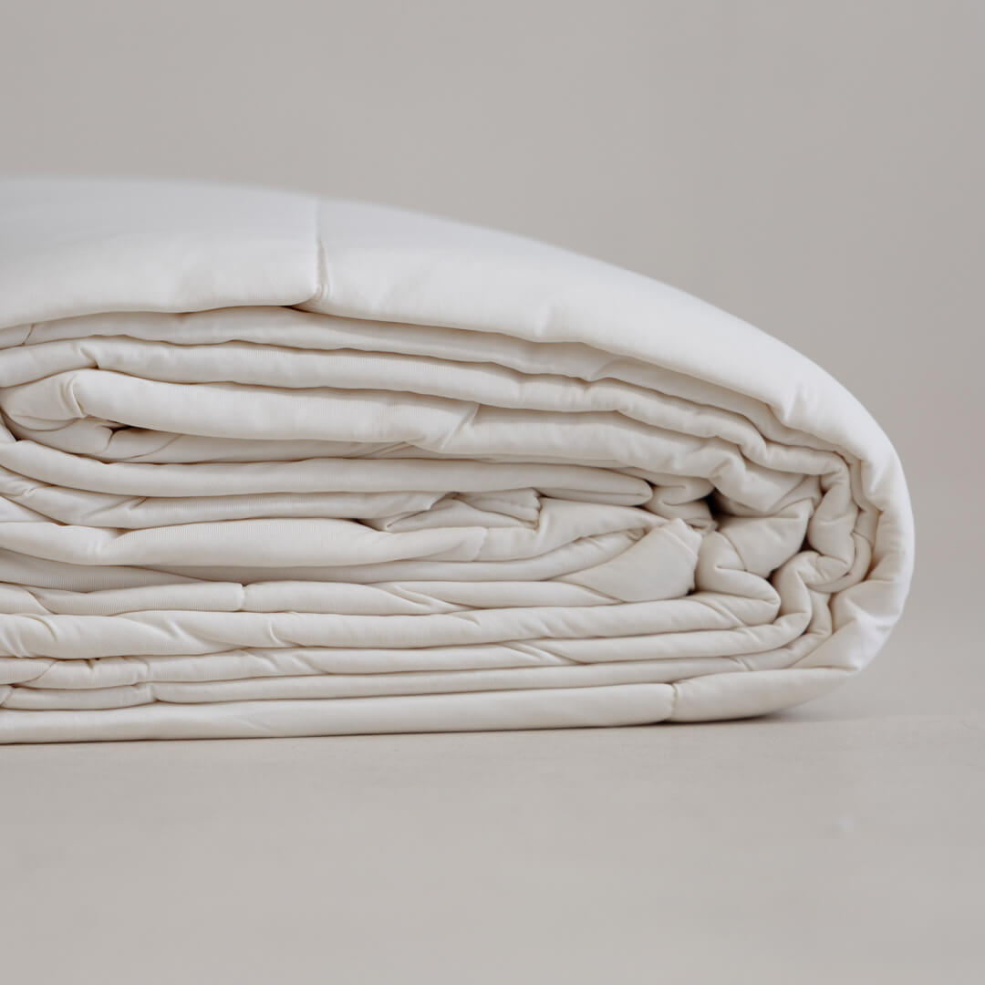 Off-white coloured cooling blanket folded.