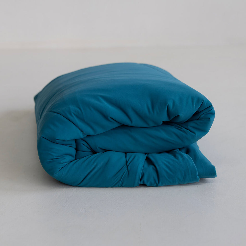 Teal coloured cooling blanket folded.