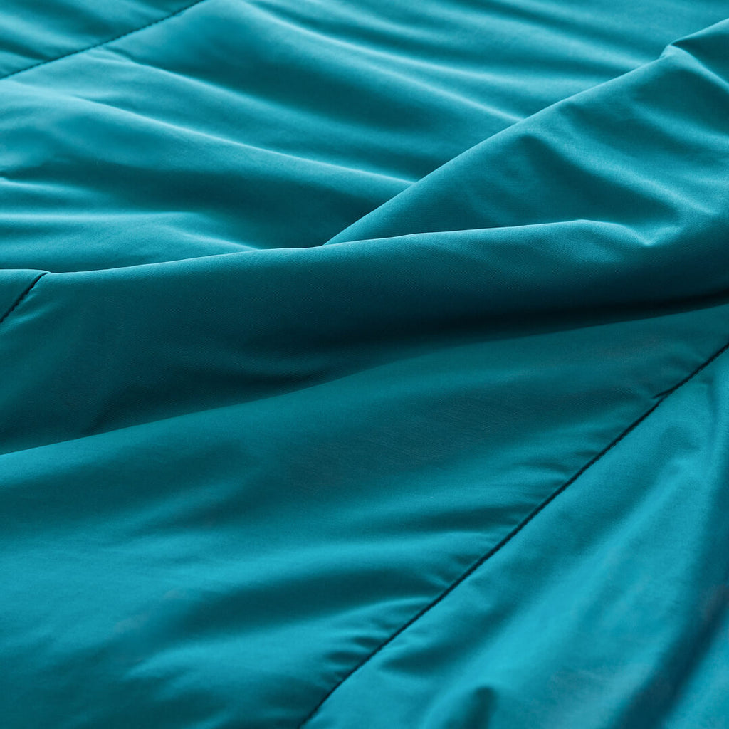 Teal coloured cooling blanket close up of fabric texture.