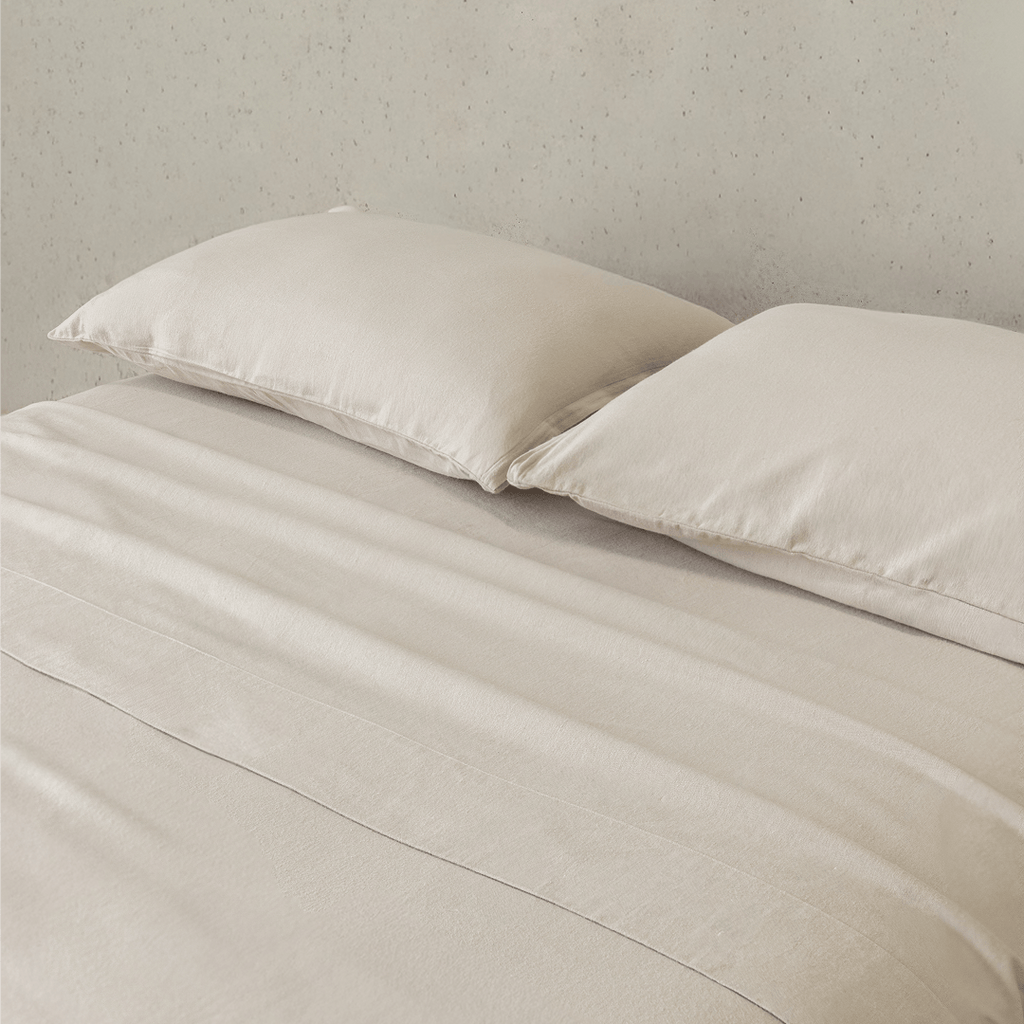 Close-up of beige fitted sheets and matching pillowcases, highlighting the soft brushed texture, warm natural color, and comfortable finish.