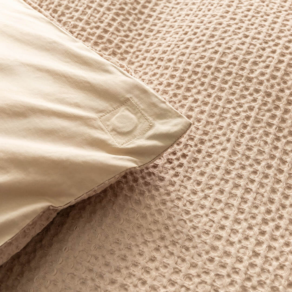 Close-up of a textured beige quilt cover magnetic corner.