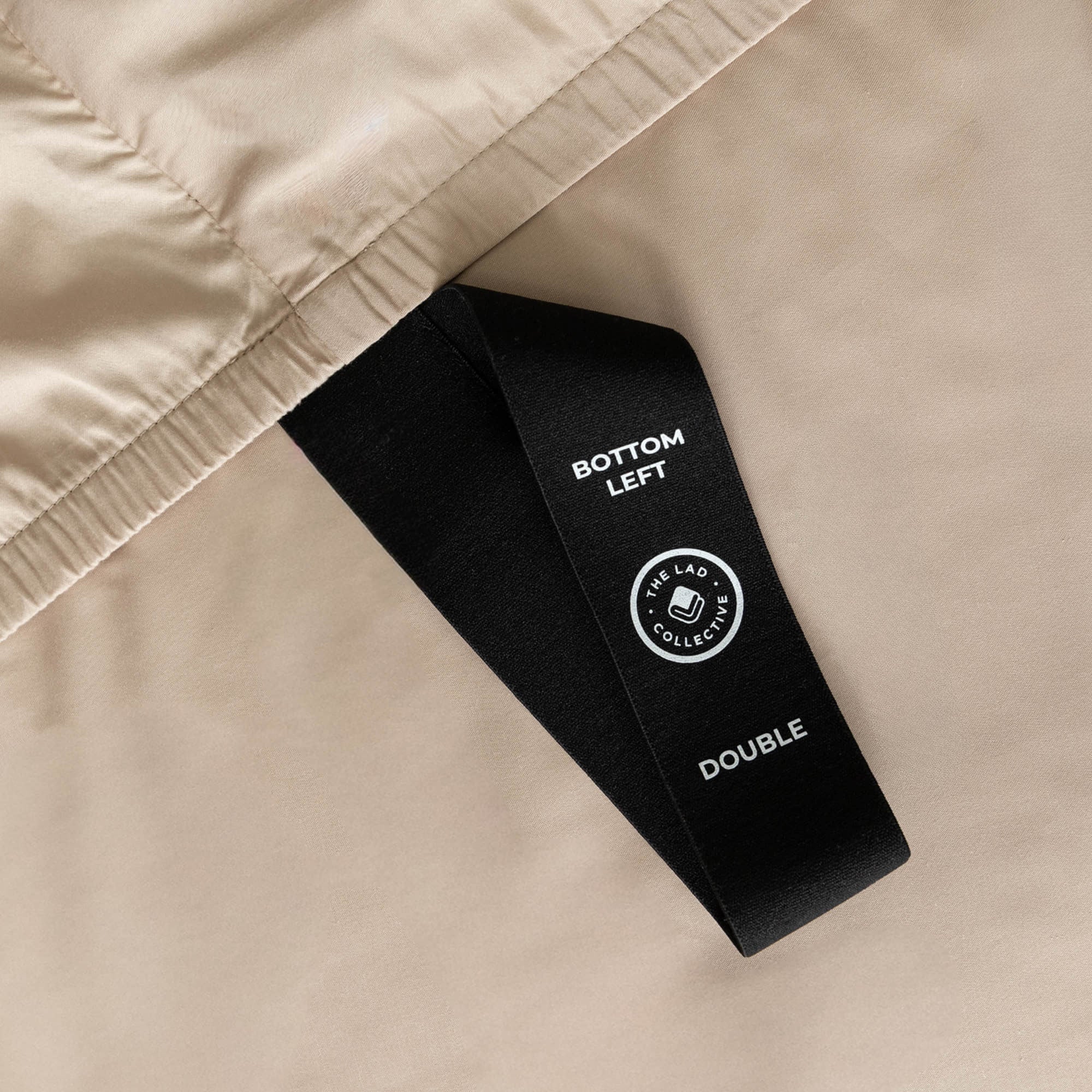 Labelled loop corner strap on fitted sheet that says 'Bottom Left', 'Double'.