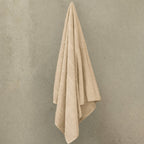 Beige bath towel hanged on wall