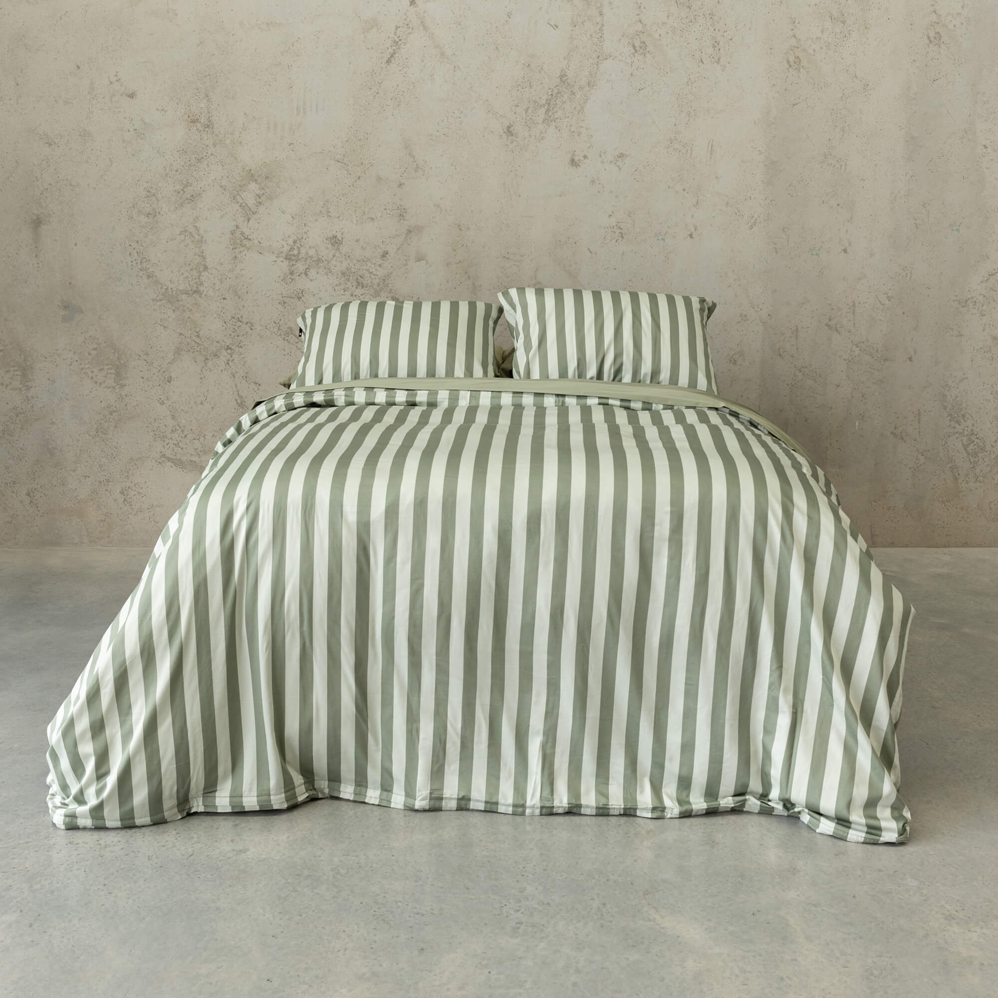 Sage green and white stripe quilt cover set on a bed, with a neutral background.