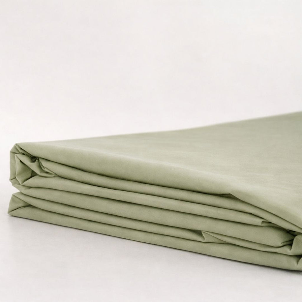 Folded green fabric on a white background.