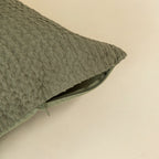Textured green pillow on a beige background, highlighting the invisible zip. 