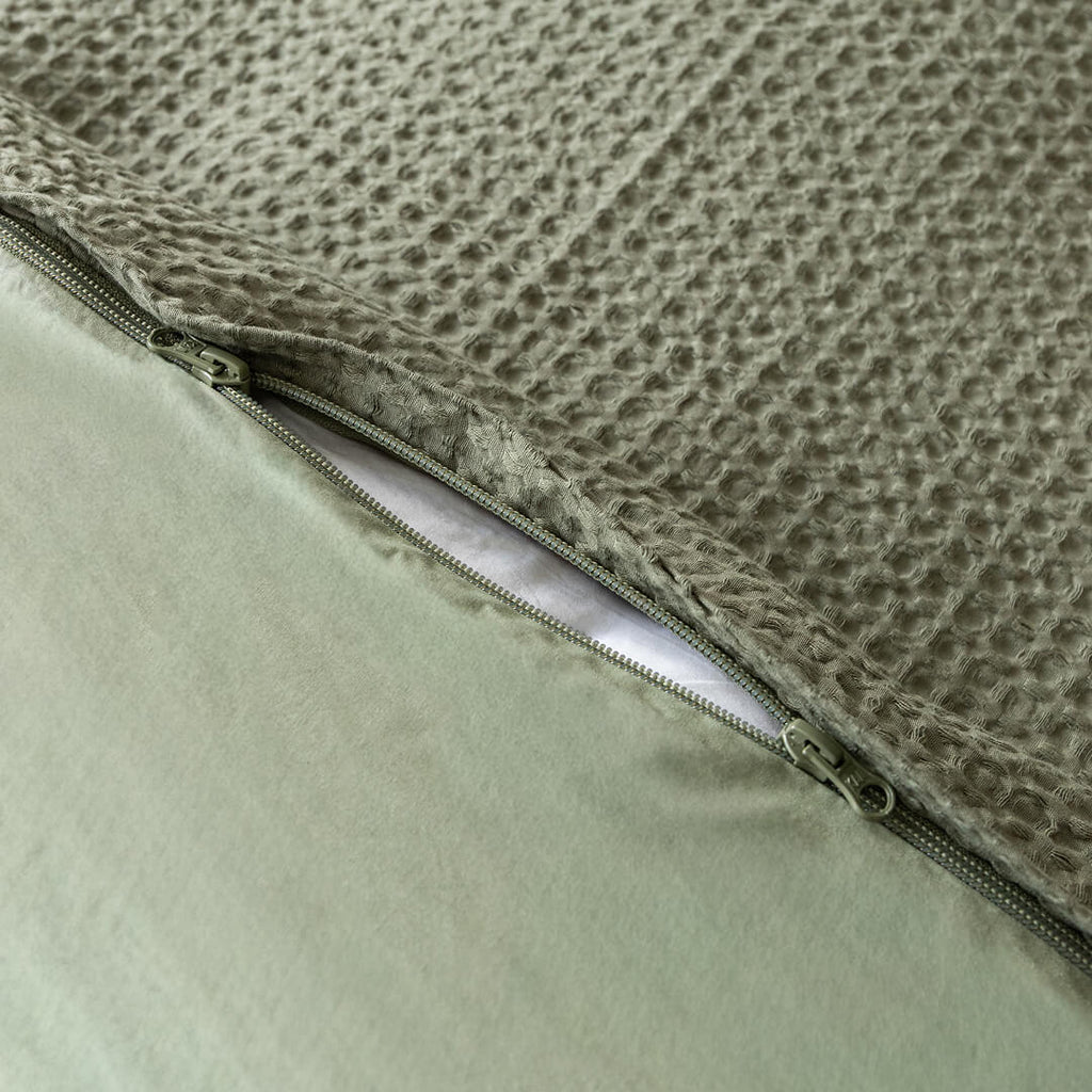 Close-up of a quilt cover with a textured surface and zipper detail.