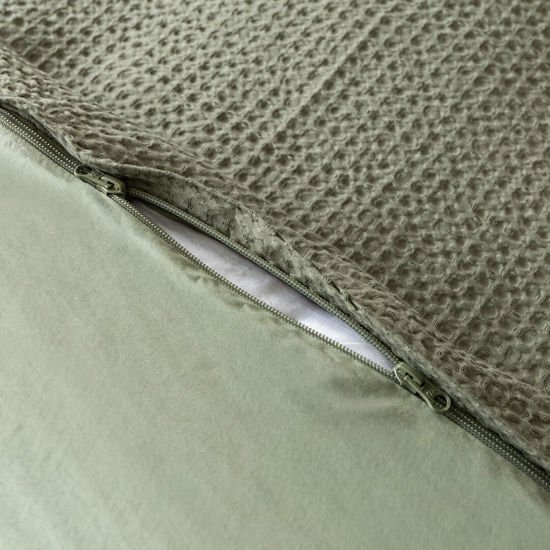 Close-up of a quilt cover with a textured surface and zipper detail.