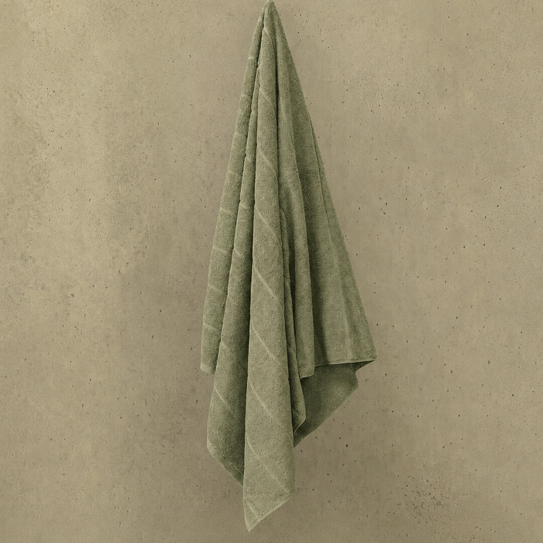 Sage bath towel hanged in wall