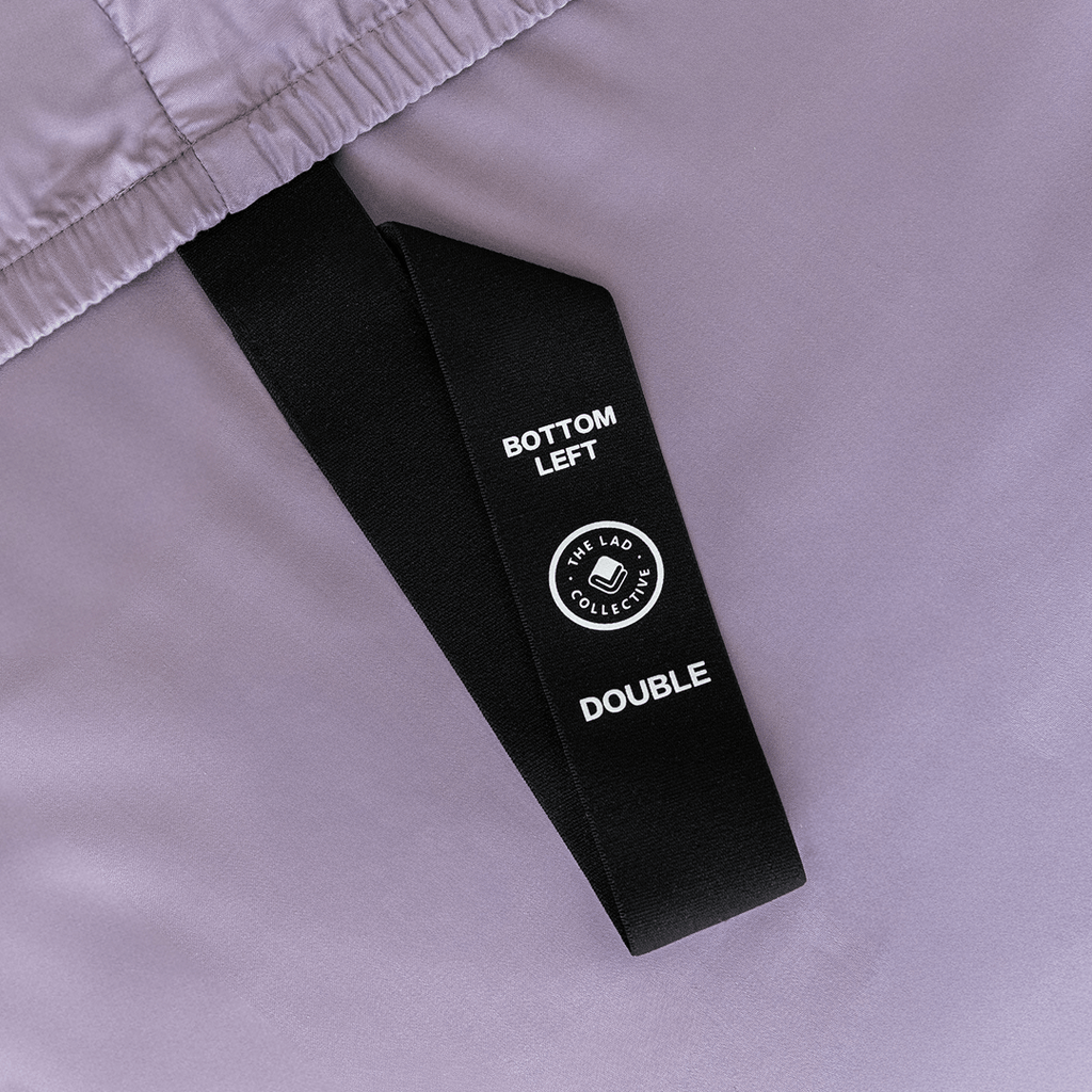 Close-up of the fitted sheet's labeled corner strap marked "Bottom Left" for quick and easy bed-making.