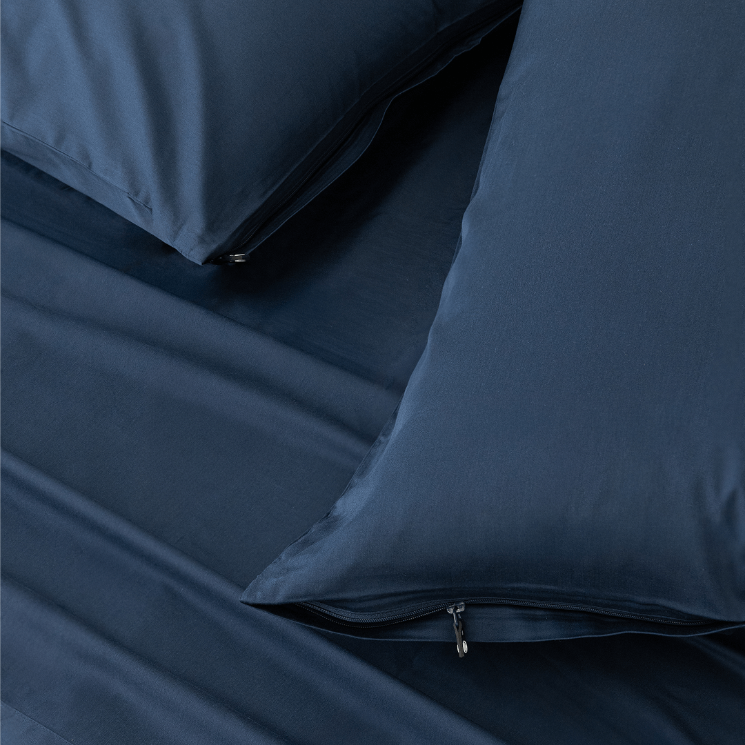 Close-up detail of navy blue pillowcases featuring hidden zipper closures