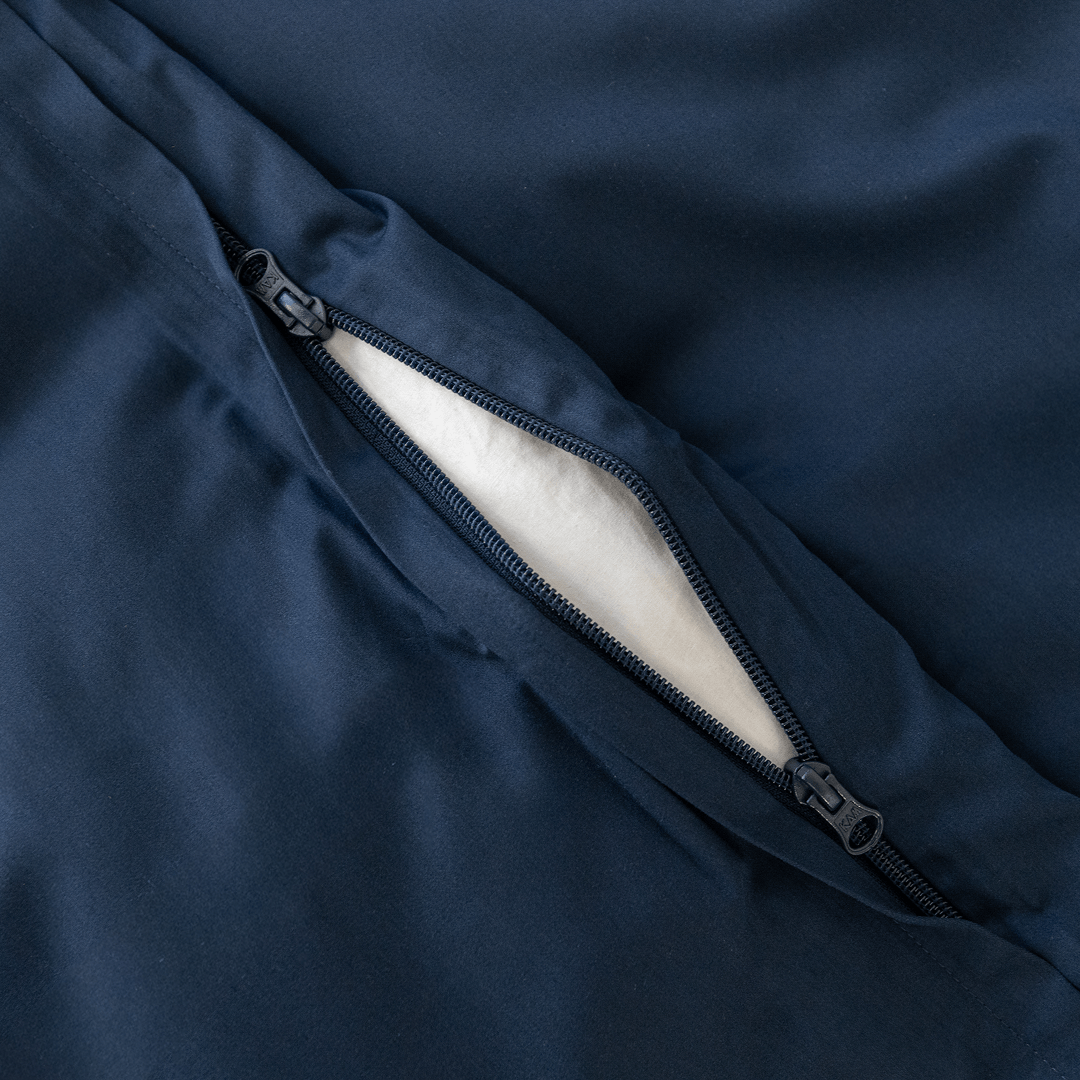Close-up detail of a navy blue quilt cover featuring a dual zipper closure