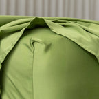 Close-up of green bedding with a neutral background.