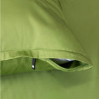 Close-up of a green pillowcase with a zipper and button detail.