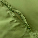 Close-up of a green zipper on a green fabric background.