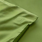 Close-up of a green quilt cover corner with magnetic clip sewn in.