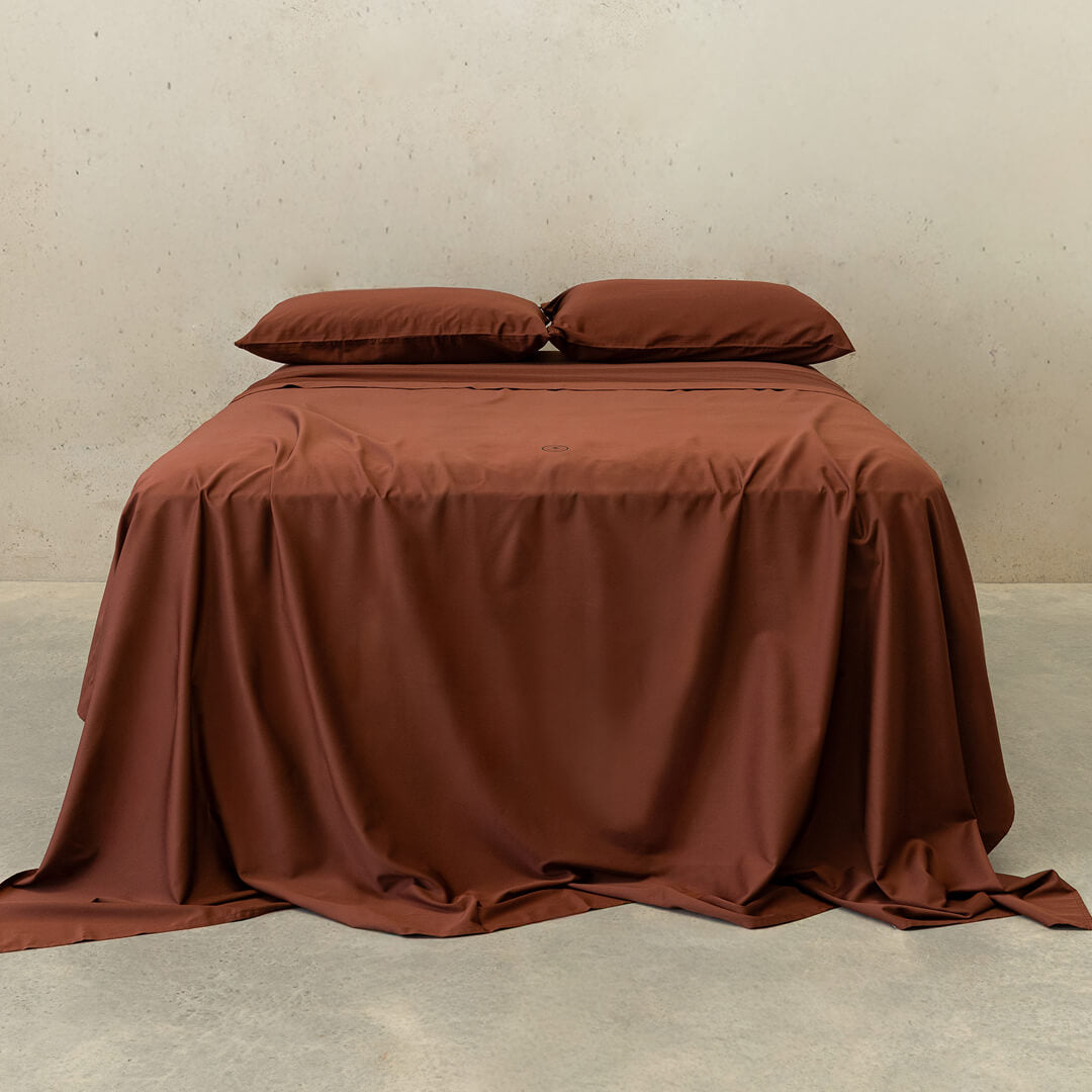 Chocolate brown bedding set on bed.