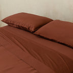 Chocolate brown bedding set on bed.