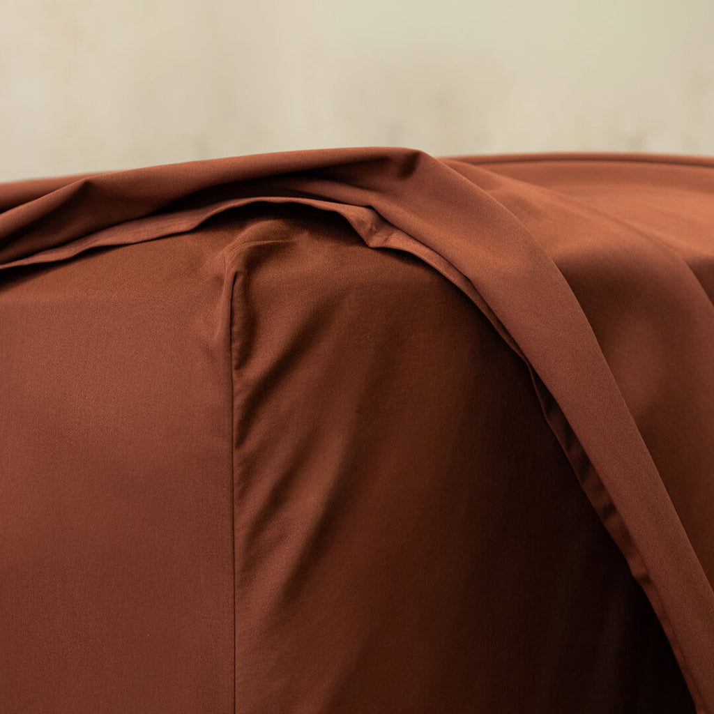 Chocolate brown fitted sheet close up of corner.