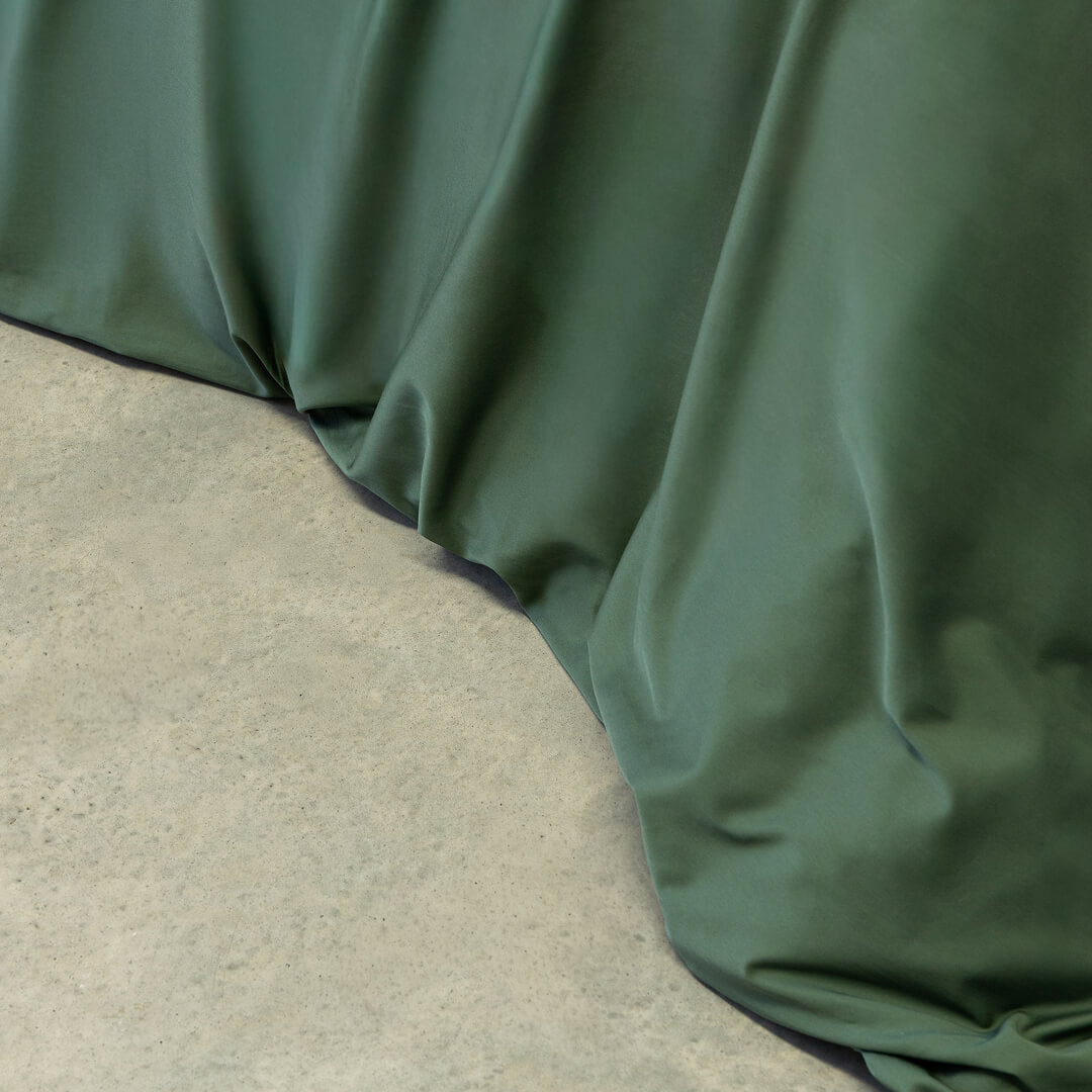 Green fabric draped over a concrete surface.