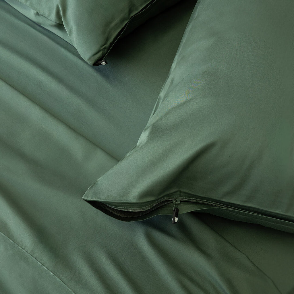 Dark green invisible zip pillowcases on the bed.