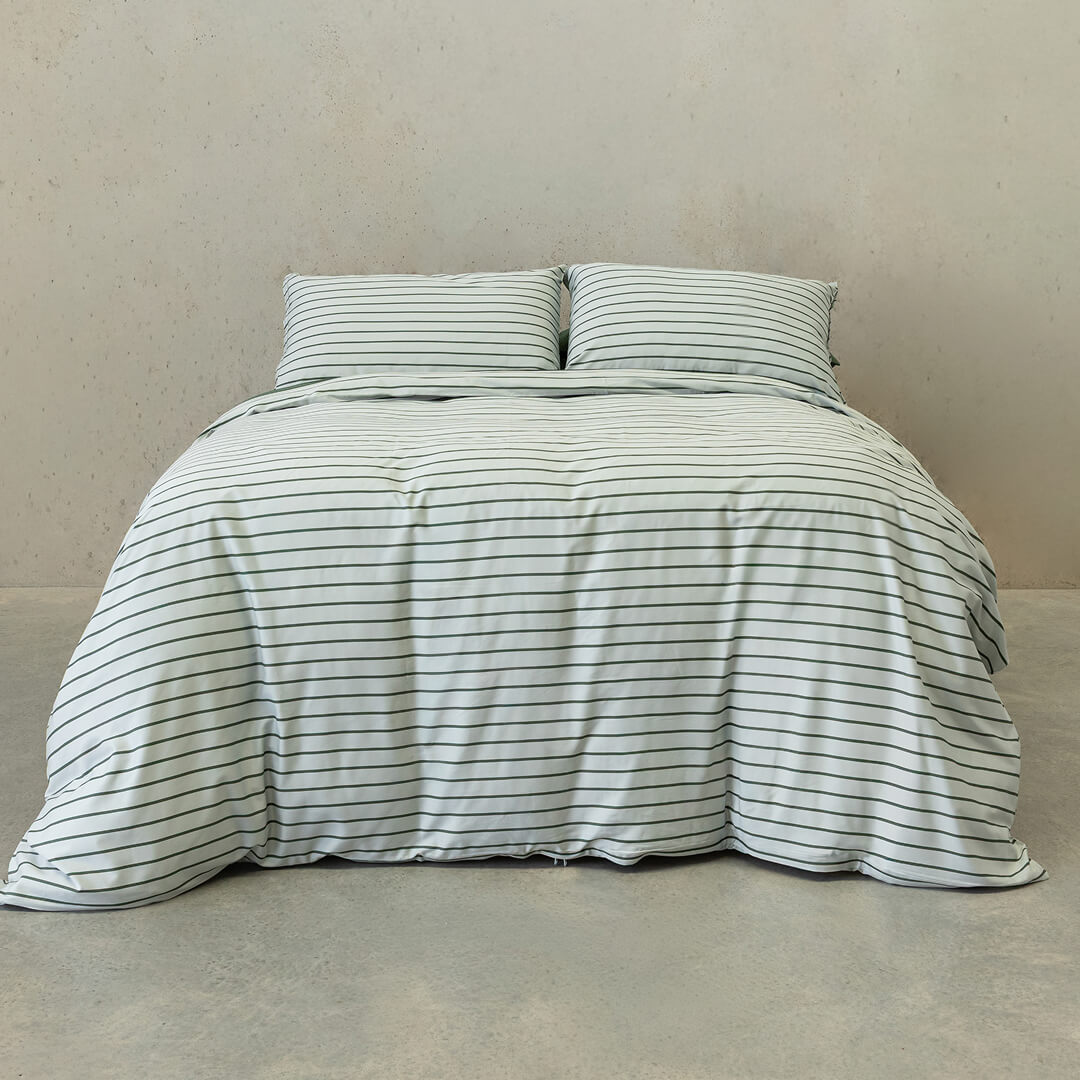 Striped duvet cover set on a bed against a beige wall