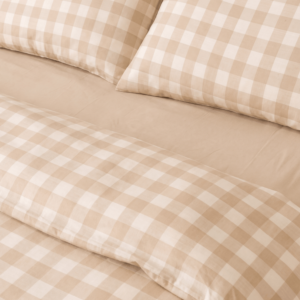 Detailed view of the quilt cover folded back to reveal the matching fitted sheet and pillowcases, showcasing the coordinated neutral bedding set.